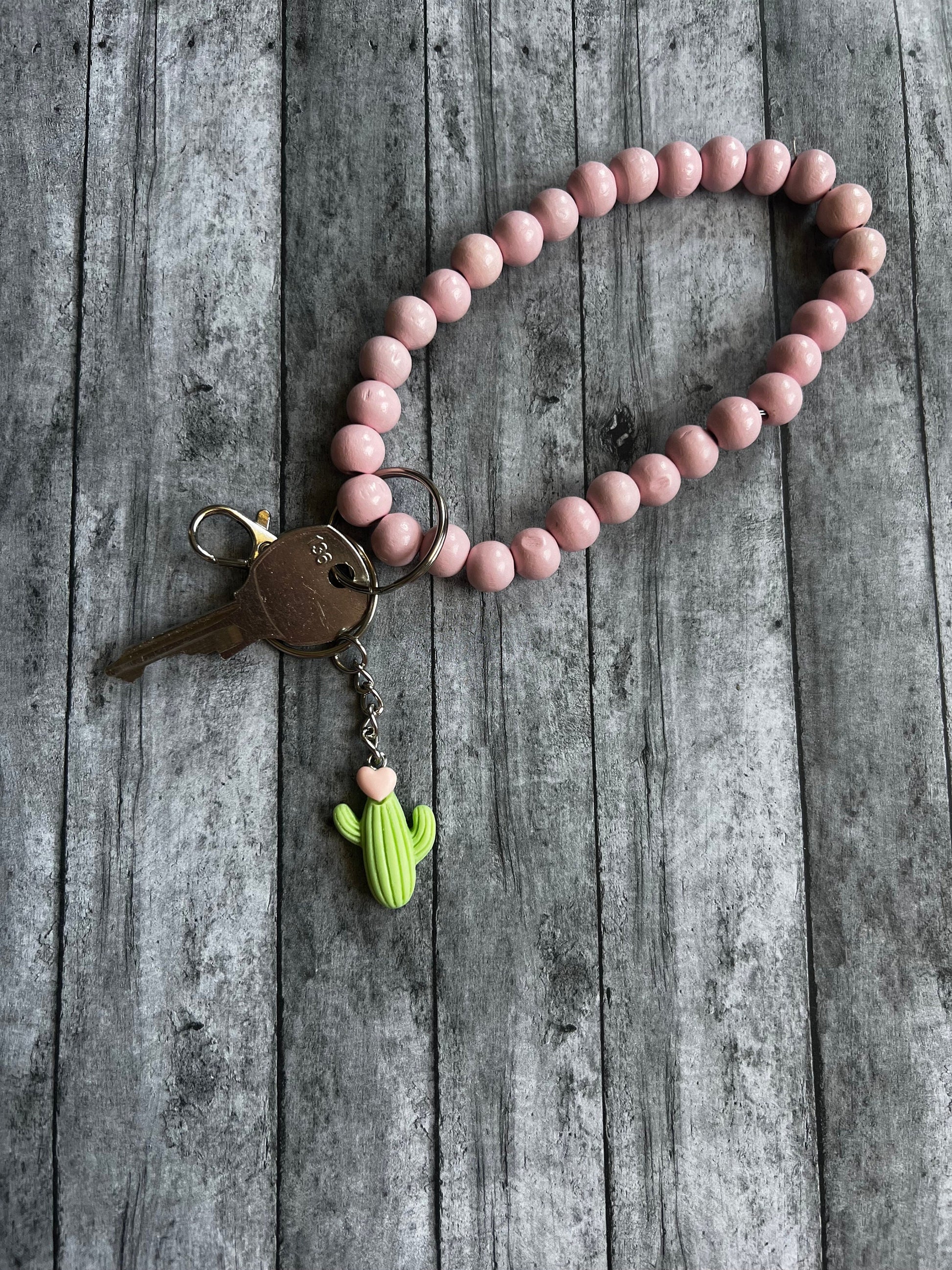 View of the Cactus keychain on a wristlet so you can see the length of the keychain. It is approximately 3 inches in length.