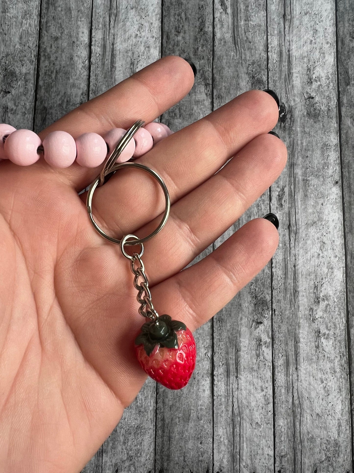 Closer view of the strawberry keychain. It would be a perfect size and length to decorate your wristlet, backpack or etc.