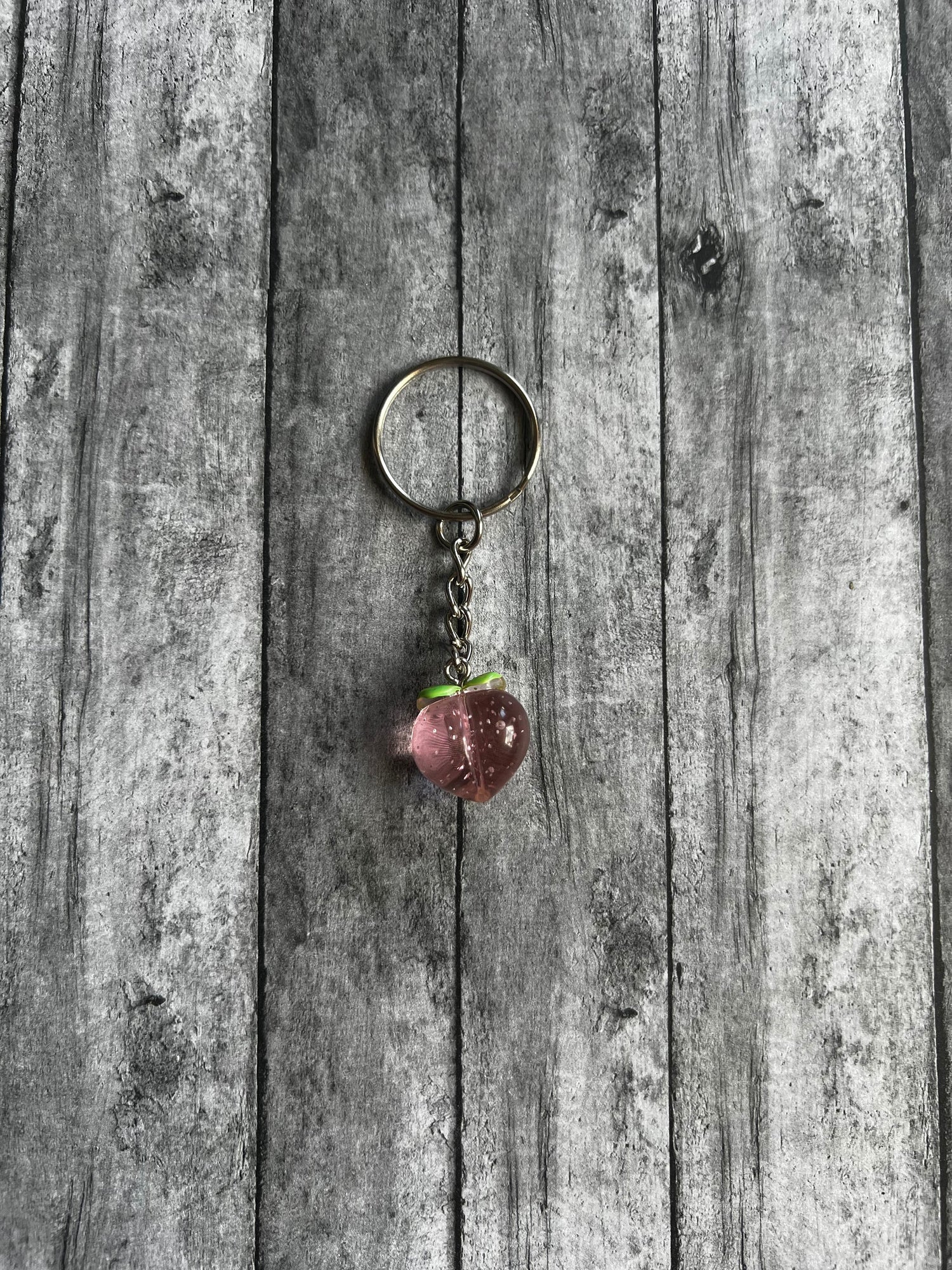 Cute, small pink peach keychain perfect to use as an accent piece for your wristlet, backpack, etc.